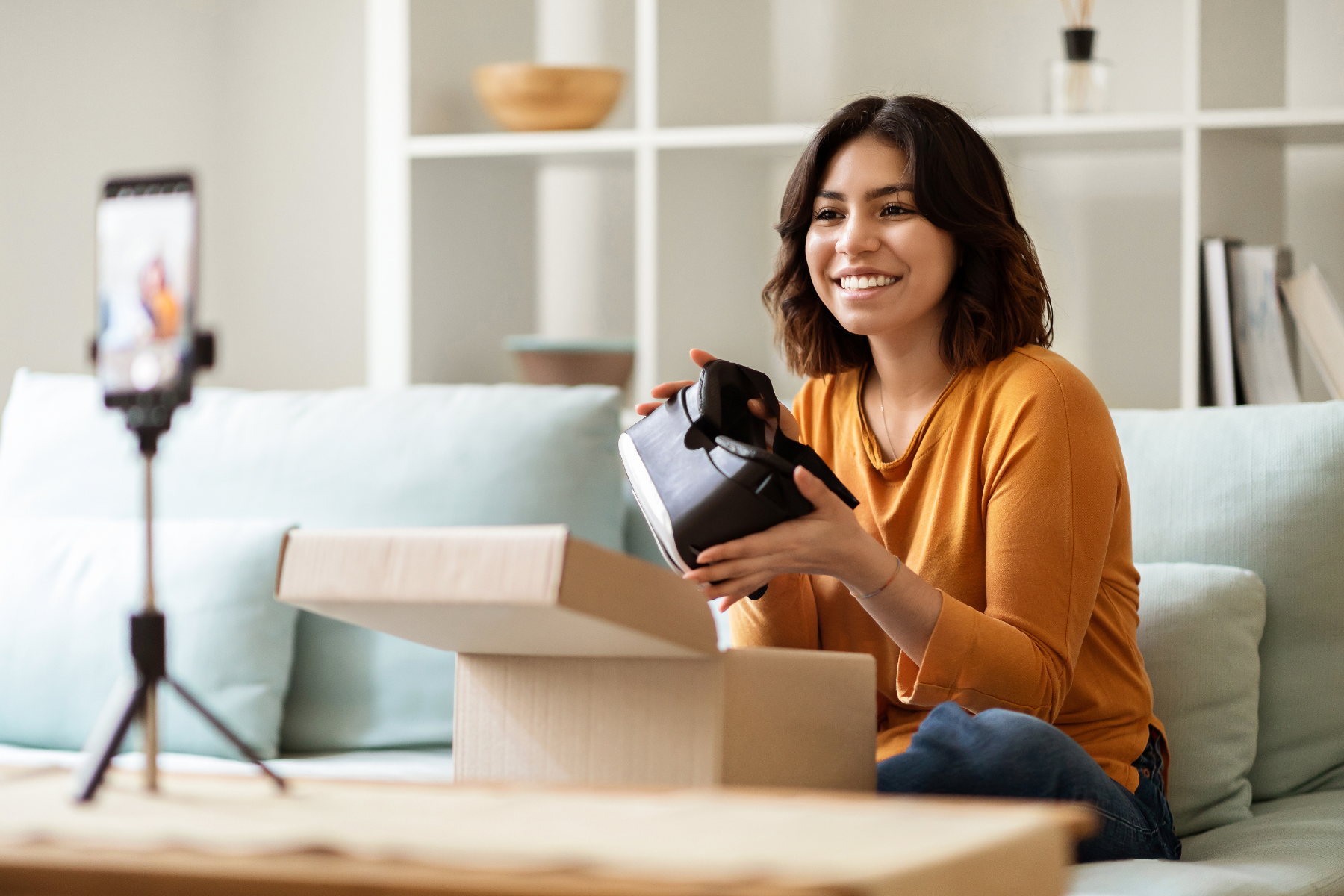 Chica grabando su video de unboxing para redes sociales, abriendo con entusiasmo un embalaje a medida